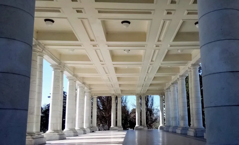 The marble colonnade of the historic Cheesman Park Pavilion in Denver, seen from beneath its coffered ceiling