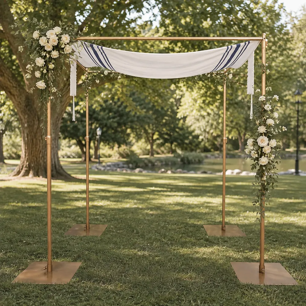 The Modern Chuppah, a four-post copper-finished chuppah frame draped with a navy-striped tallit and trimmed with white roses